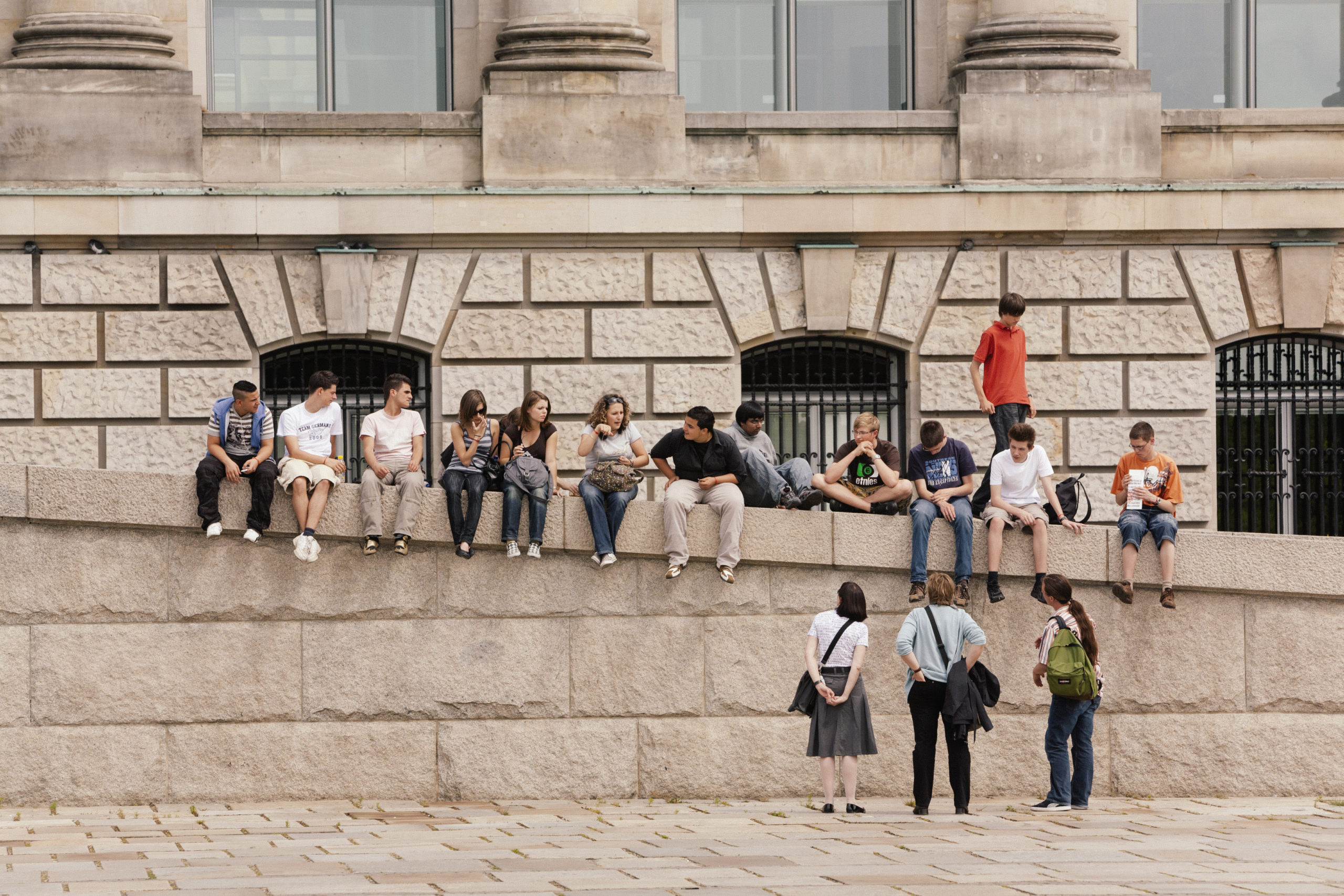 A tour group sitting on the steps at the Reichstag in Berlin, Germany