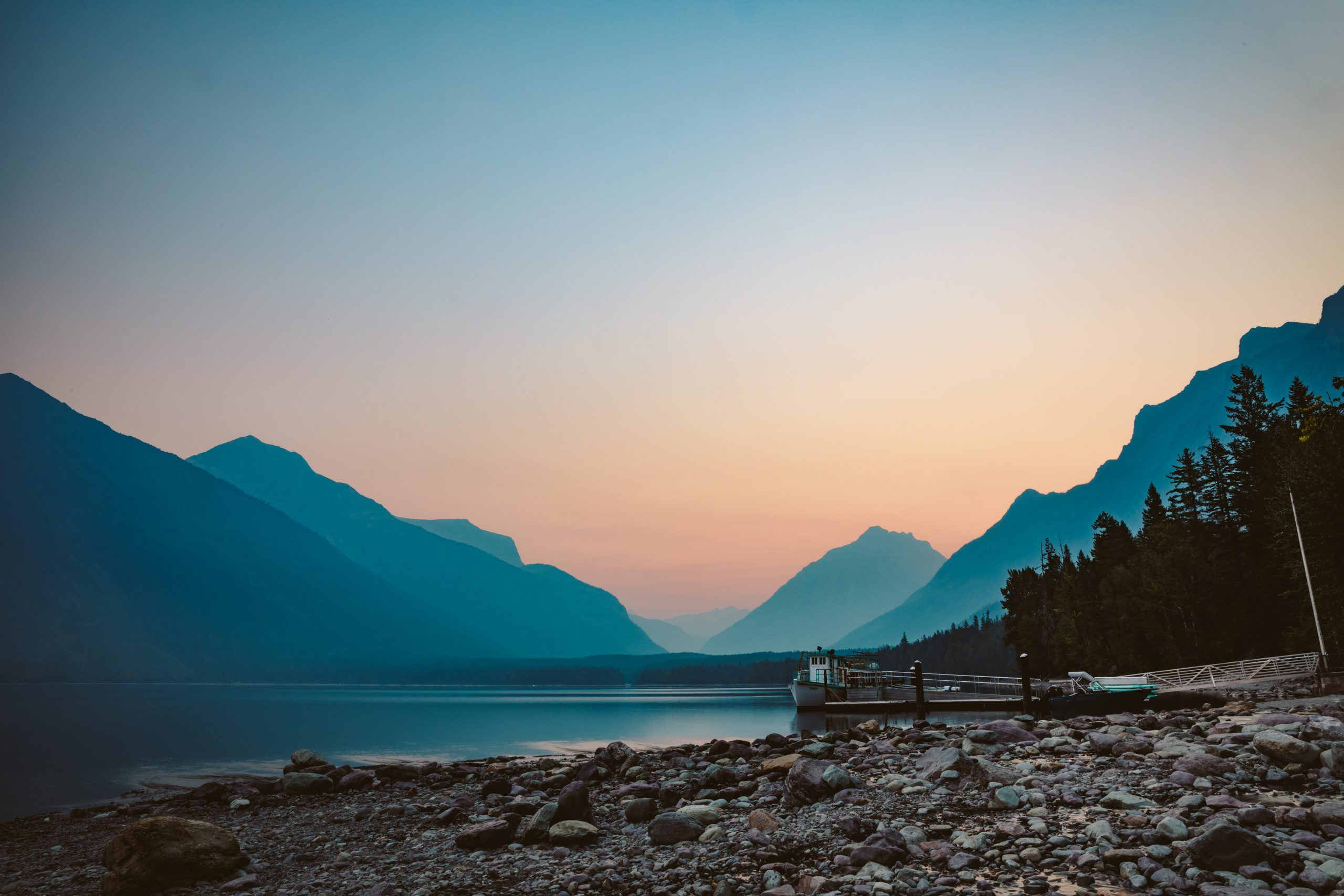 A smokey, haze filled sunrise on Lake McDonald taken from the shore behind Lake McDonald Lodge