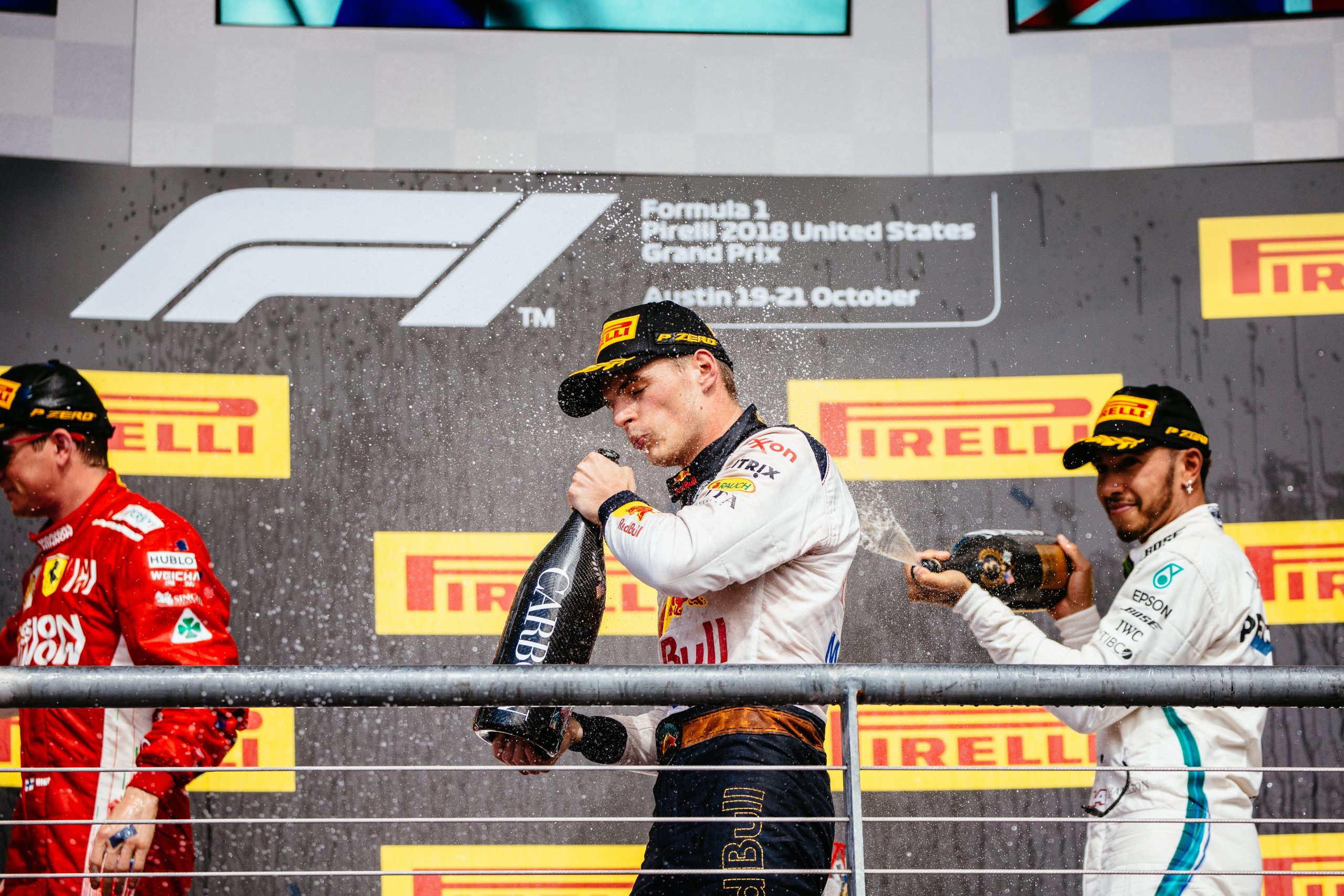 Lews Hamilton spraying Max Verstappen with champaign on the podium