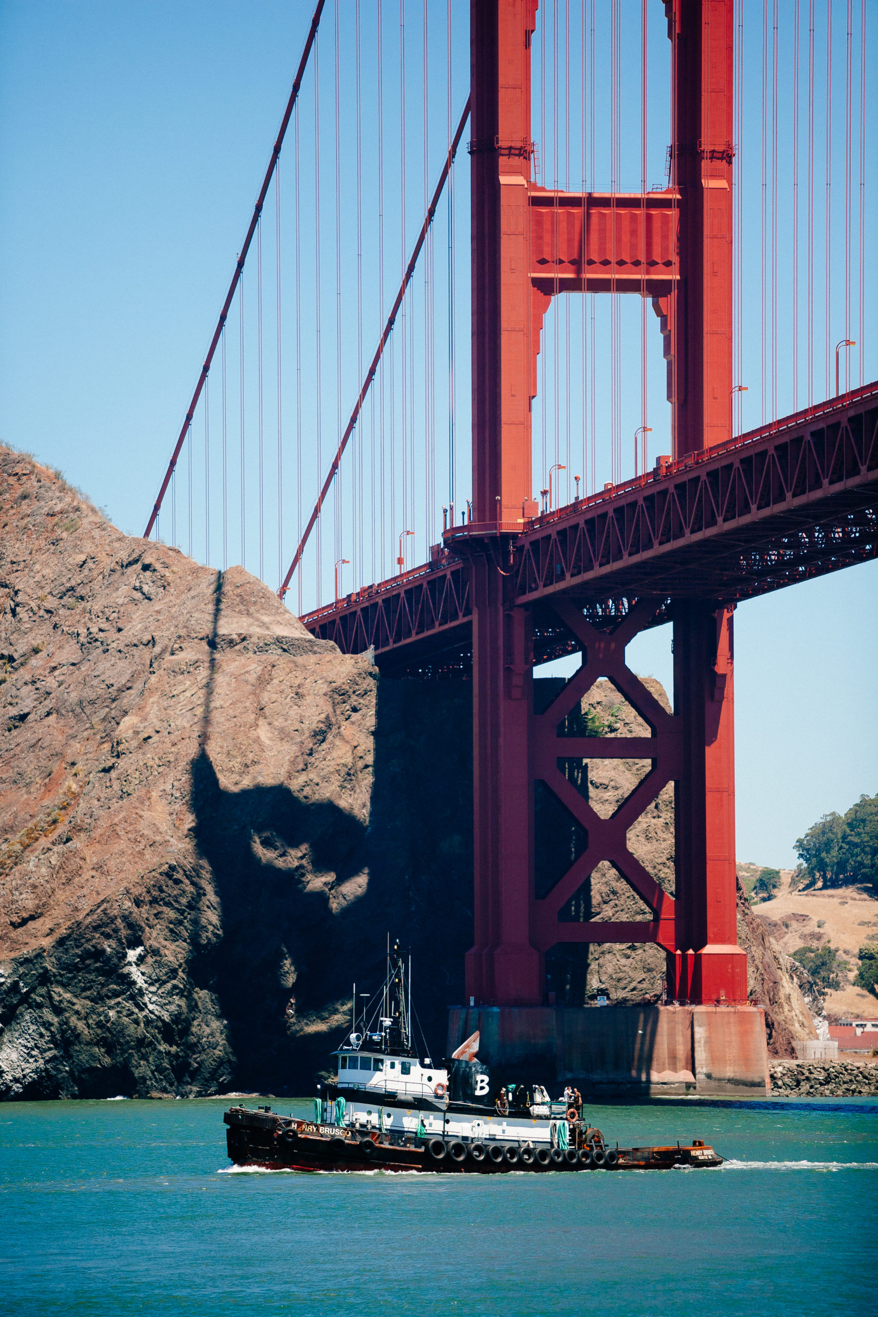 A boat floats underneath the Golden Gate Bridge in San Francisco, California.